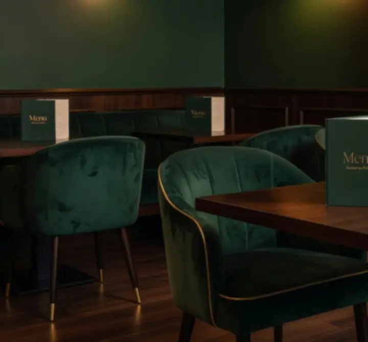 Stół w eleganckiej kawiarni Chipmora z menu, kieliszkami i kartami do gry