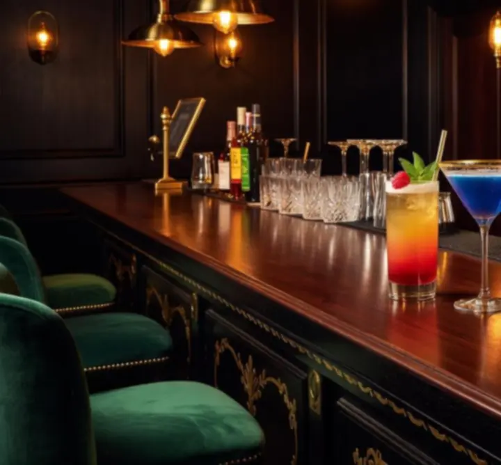 Autorskie koktajle w barze Chipmora na tle butelek whisky i wina